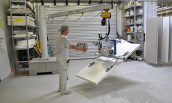 Slewing pillar crane with vacuum lifter lifts door