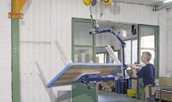 Slewing pillar crane with vacuum lifter lifts table