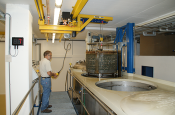 Crane system for low room height Crane system lifts metal container out of basin