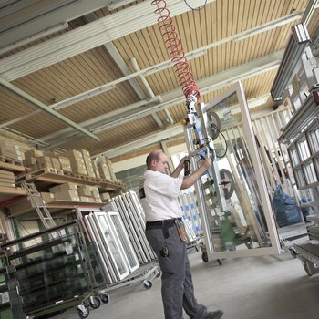 A fully assembled window is lifted from the work table by crane and brought to the transport trolley