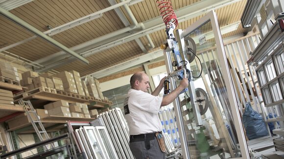 A fully assembled window is lifted from the work table by crane and brought to the transport trolley