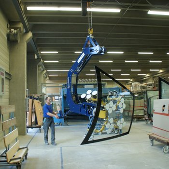A windscreen is brought to the transport trolley by means of a vacuum lifter