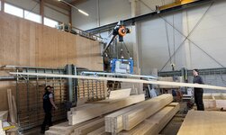 The vacuum handling system, including wall-mounted slewing crane and electric chain hoist, is used to transport panels around the Striebig panel saw.