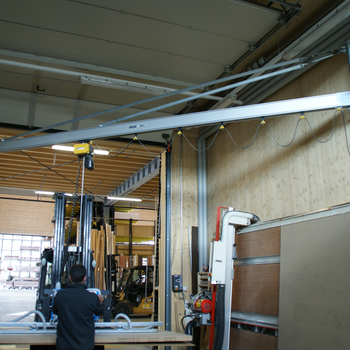 Wall-mounted slewing crane with vacuum handling system The GIS handling system integrated into the confined space, consisting of aluminium wall-mounted slewing crane, with electric chain hoist and new vacuum lifting device