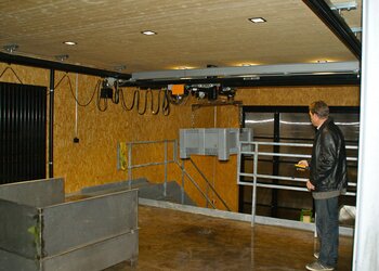GISKB Crane for transport of plastic containers A plastic container is gently lifted by the GIS electric chain hoist and transported from the ground floor to the stage on the ground floor.