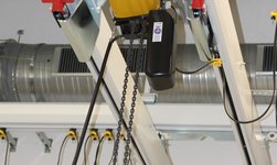 Electric chain hoist is placed between crane girders for maximum lifting height
